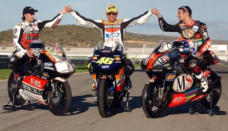 Rossi posa sobre su Honda de MotoGP con el número 46 flanqueado por Arnaud Vicent (125) y Marco Melandri (250), ambos con el 1 en su carenado, en la foto de campeones del mundo de 2002
